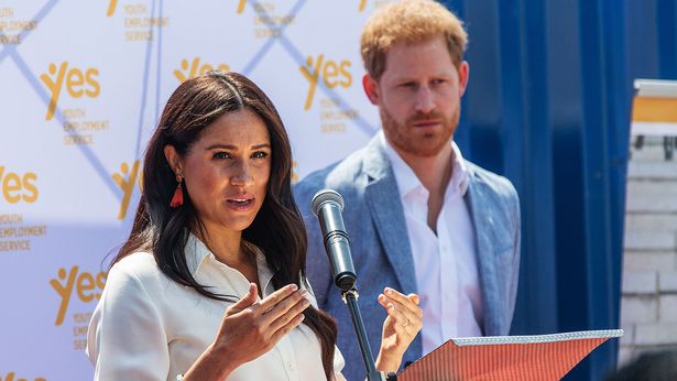 Meghan Markle, Duchess of Sussex(L), is watched by Britain's Prince Harry