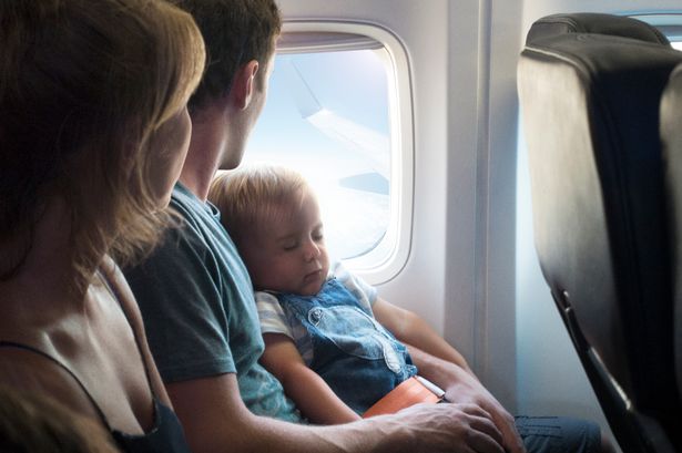Baby asleep with family on plane