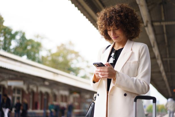 Woman using phone at train station