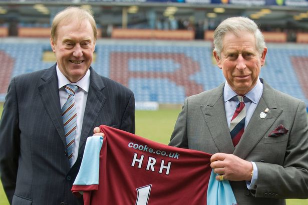 Prince Charles poses with Burnley Chairman Barry Kilby (L) while holding a Burnley football shirt 