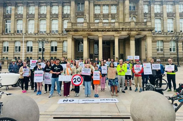 Campaigners gather in Victoria Square to mark 23 road deaths in a year, with 23 white roses marking each one