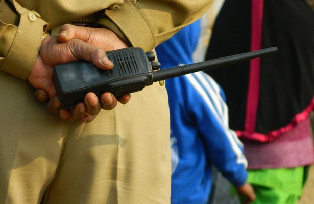 Indian police man holding a walkie talkie