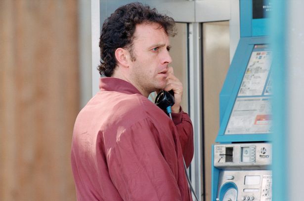 The filming of the Brookside episode where Barry Grant sets fire to Jimmy Corkhill's shop, Kowboy Kutz. Pictured, actor Paul Usher who plays Barry Grant phones the Fire Brigade after setting the shop on fire. 9th September 1992.