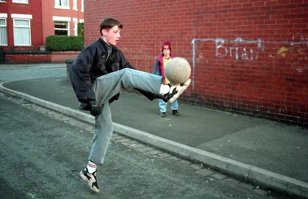 Kids play football in the street in Moss Side in 1993