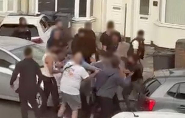 A group of men can be seen remonstrating outside a row of houses along Showell Green Lane before punches start being thrown