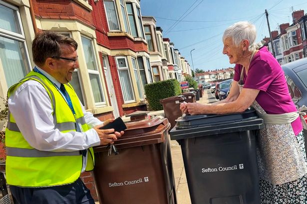 Kevin Shields, from Sefton Council's Waste Management & Street Cleansing team, delivers new wheelie bins to a resident in Derby ward in Bootle 