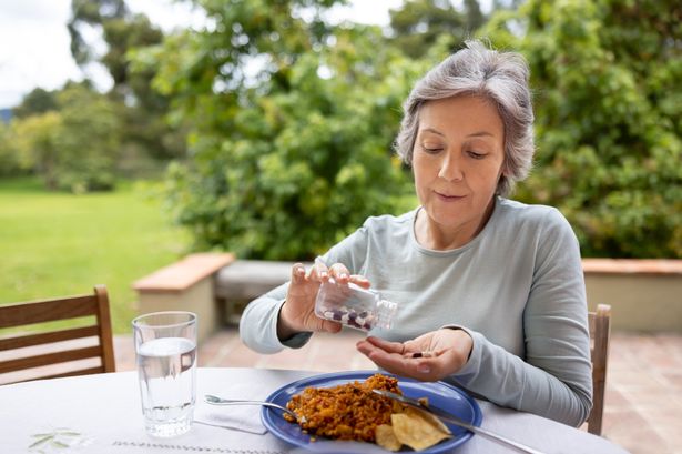An old person taking her medicines