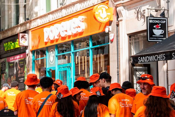 Photo shows people in Popeyes merchandise queued up outside restaurant