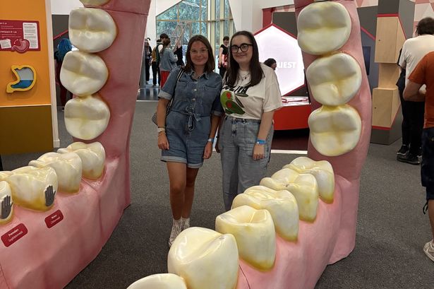Two women stood in giant teeth