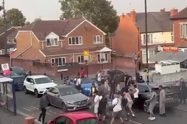 A huge fight broke out in broad daylight on a residential street in Birmingham last week and was captured on film, with a man brandishing a large knife attempting to slash two men during the melee