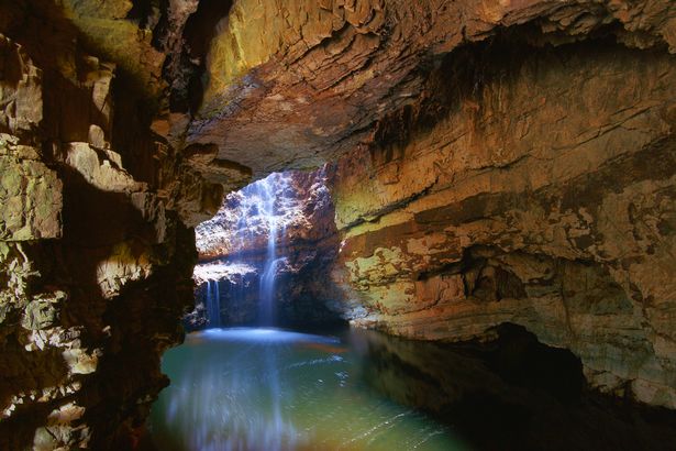 Smoo Cave with waterfall illuminated by natural daylight, Sutherland, Scotland.