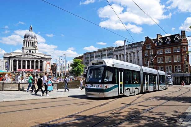 Modern tram passing the Council House also known as the city hall in the Old Market Square, Nottingham, Nottinghamshire, England, UK, Western Europe.