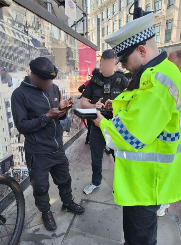 Officers speak to a delivery rider in Manchester