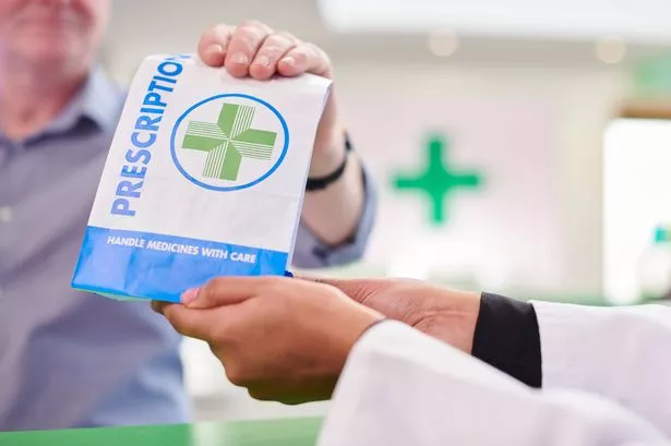 female pharmacist handing prescription