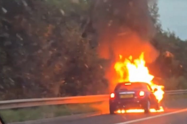 The Mini on fire on the M77.