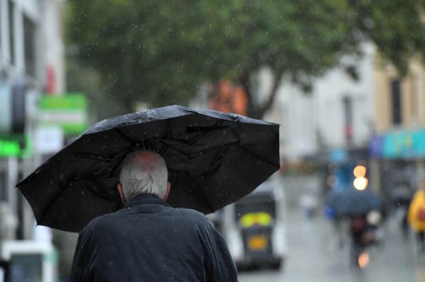 Man walking rainy street with umbrella