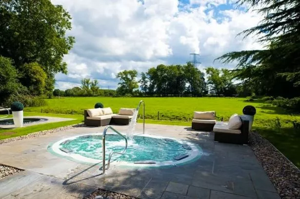 A pool outside next to a lawn at Thornton Hall, Wirral