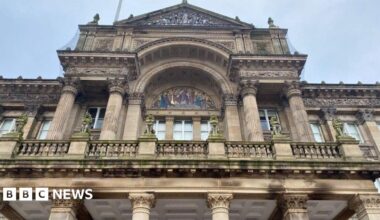 A view of Birmingham City Council House, with the camera pointing upwards. An upper floor with windows is prominent on the photo.