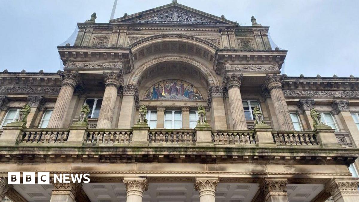 A view of Birmingham City Council House, with the camera pointing upwards. An upper floor with windows is prominent on the photo.