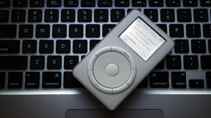 An Apple iPod resting on top of an Apple Mac laptop to showcase the different technologies.
