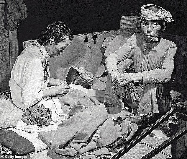 Survivors of the US attack on Hiroshima sit in a makeshift hospital that was set up in a bank building in the ruined city