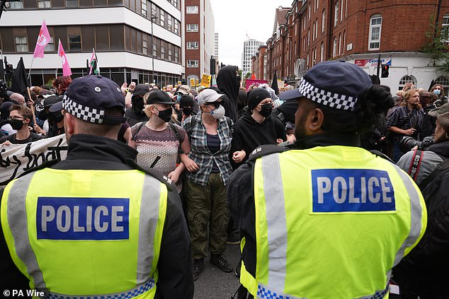 Masked counter-protesters chanting 'we are anti-fascist' gather outside the hotel in central London