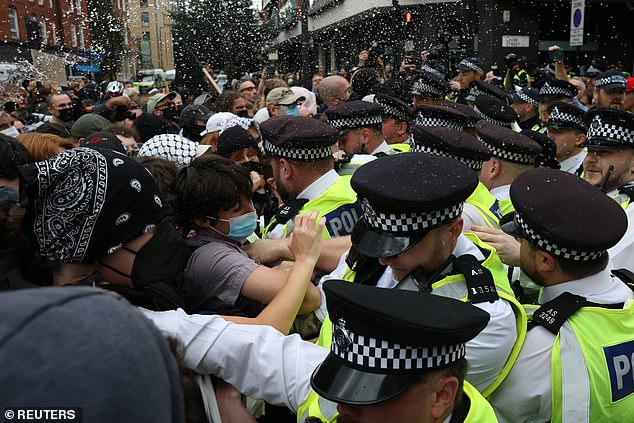 Officers and counter demonstrators clash in north London today amid anti-migrant hotel protests