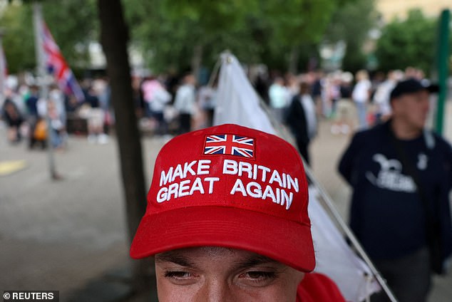 A man protesting with 'Thistle Barbican needs to go - locals say no' group wears a 'Make Britain Great Again' hat