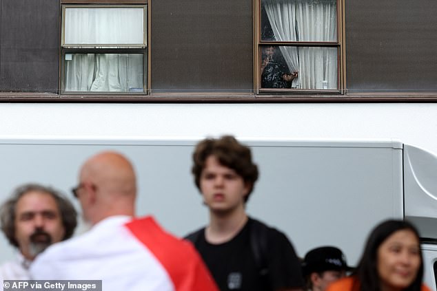 A person can be seen peering behind a curtain inside the Thistle City Barbican Hotel