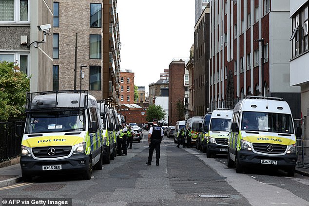 Police vans line the streets outside of the Thistle Cit6y  Barbican Hotel in Islington as police patrol the area