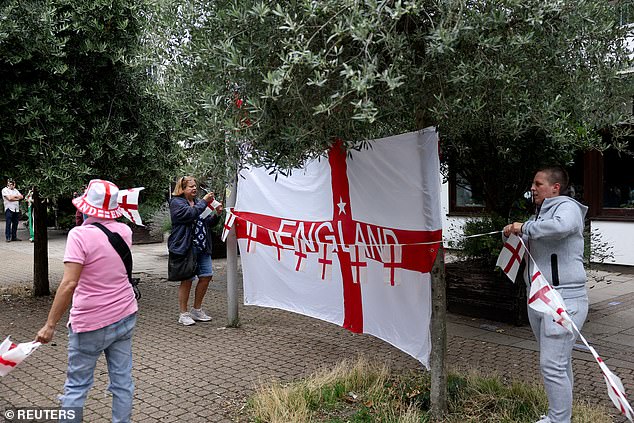 Anti-immigration protesters hold up an array of St George's flags at the demonstration today