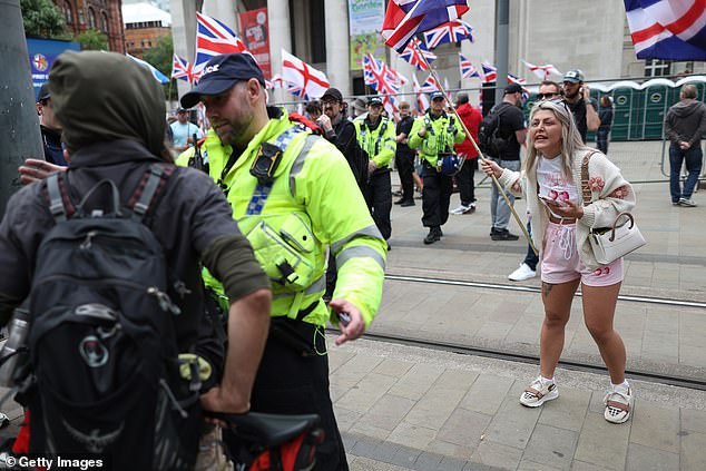 MANCHESTER: Police speak to people as a woman holding a flag gestures during the Britain First March