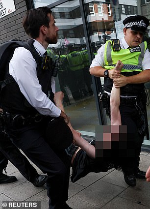 Another demonstrator was also hauled by their arms and legs out of the protests today