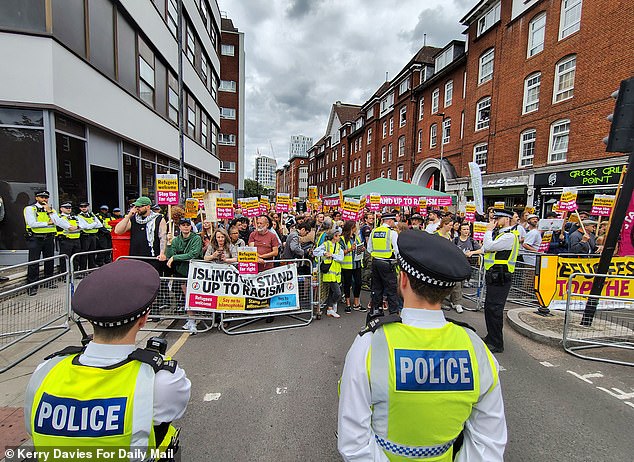 Stand Up to Racism protesters behind a barricade with a sign which says: 'Islington stand up to racism