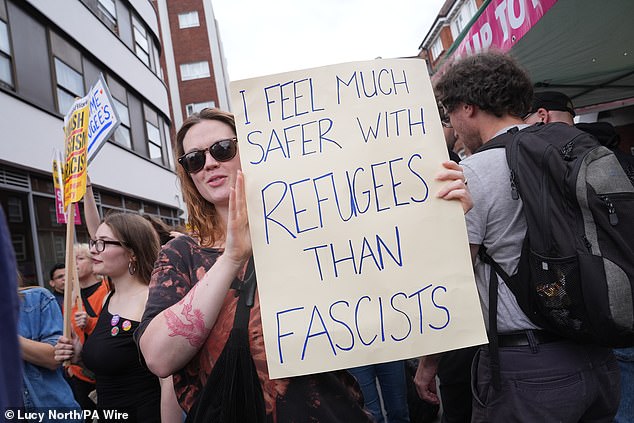 A counter protester holds up a sign, which reads: 'I feel much safer with refugees than fascists'