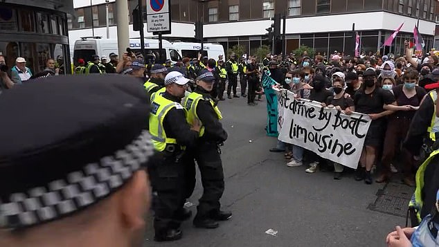 Police form a barricade as counter protesters approach amid ongoing protests outside the Thistle Barbican City hotel today