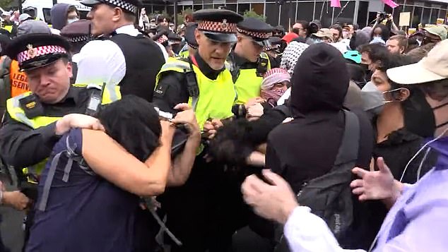 Police clash with counter demonstrators as they block a junction outside the hotel in breach of conditions set by the Met