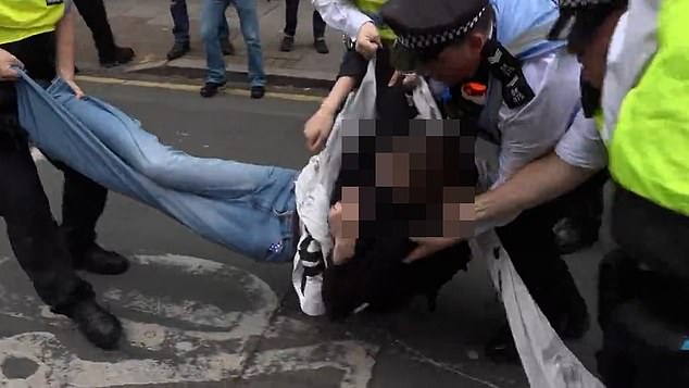 A protester being detained by police amid the demonstrations today