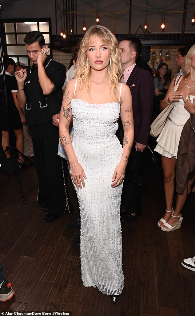 Showing off her array of tattoos down her arms, the star styled her blonde locks in voluminous curls and accessorised with dangly silver earrings