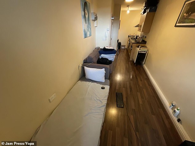 The studio-style home is essentially one long, narrow room with a single mattress laid out on the floor next to a sofa