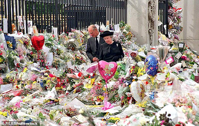 Queen Elizabeth II and Prince Philip look at the floral tributes to Diana left outside Buckingham Palace on the eve of the Princess's funeral