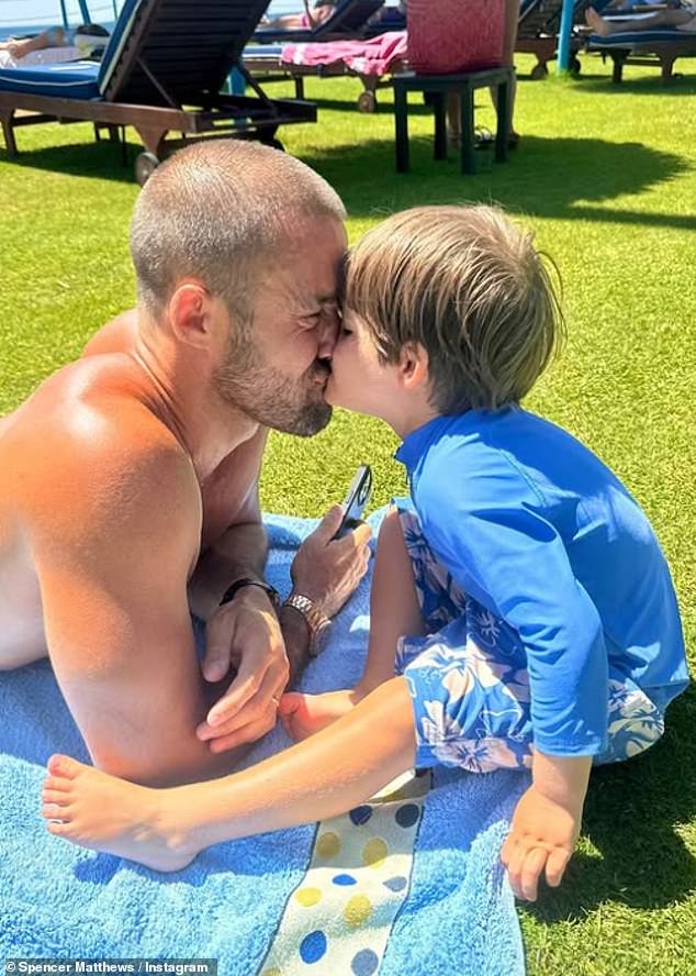Spencer lay on the grass with his little boy during the holiday