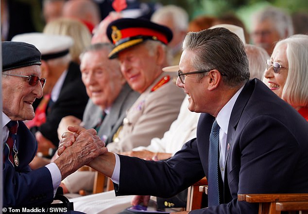 The King and Queen and PM Keir Starmer sit with veterans at a Service of Remembrance