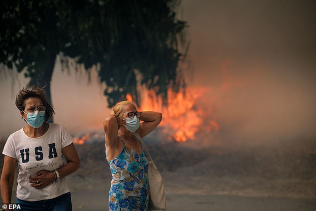 The sky is completely amber as an angry blaze continues to tear its way through the forest, making the air thick with smog
