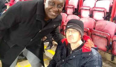 This is Mark Mogan, the disabled Liverpool fan, pictured right with Emile Heskey, who was arrested for allegedly shouting racist abuse at Bournemouth player Antoine Semenyo