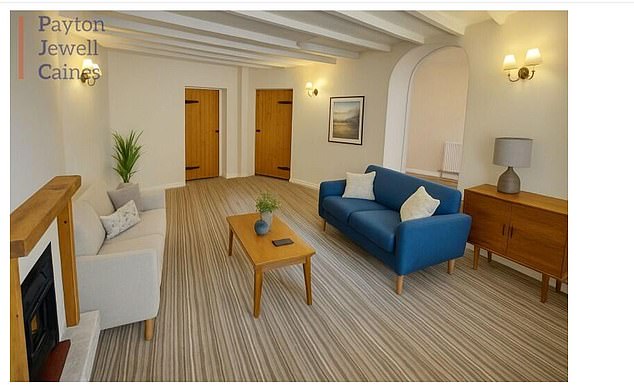 A spacious living room pictured on the listing has two colourful settees, a coffee table, lamps and wall fittings