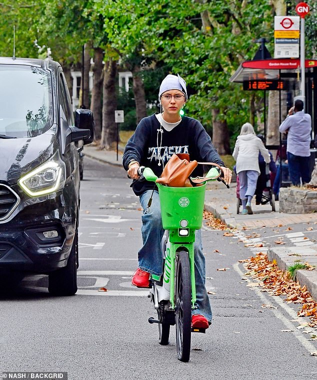 Iris Law cut a casual figure as she wobbled through busy traffic on a punctured Lime Bike in central London on Thursday
