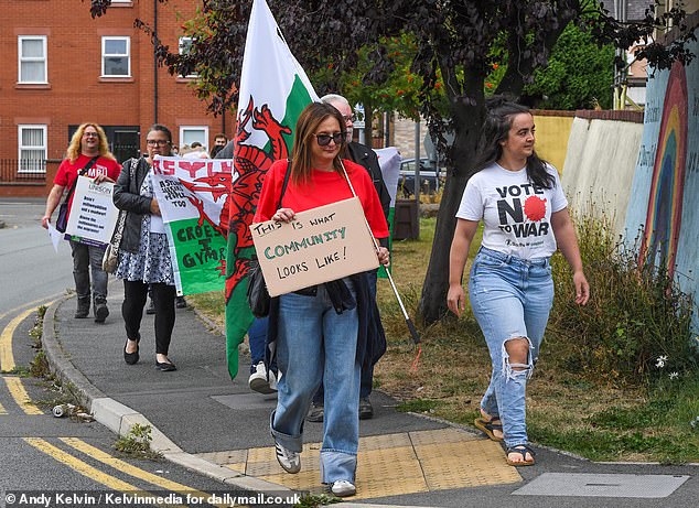 Pictured: Counter-protestors in Mold arrive at the anti-immigration protest holding Welsh flags
