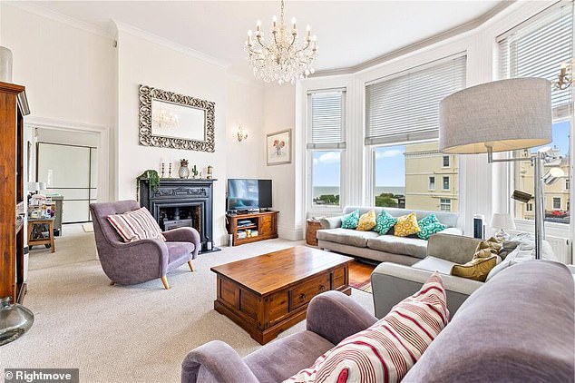 The light and airy apartment's large living room boasts sweeping views of Hove's seafront