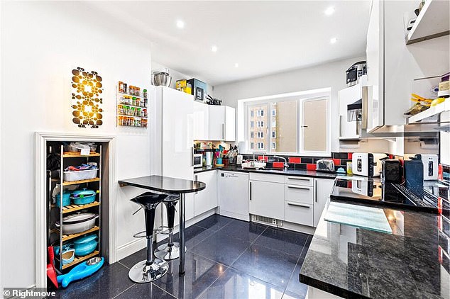 Pictured: The kitchen of Rayner's latest acquisition featuring white cupboards and sleek black surface tops